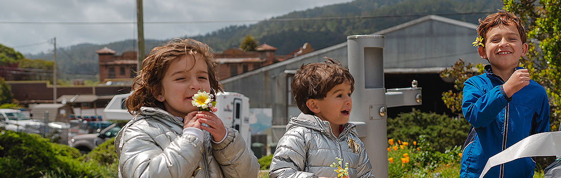 Kids smiling while smelling flowers