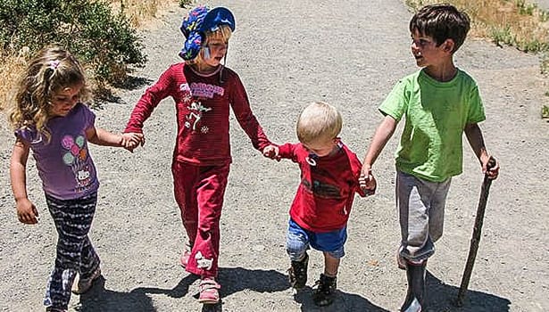 Kids on trail holding hands