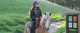 Young woman riding a horse at Rush Creek