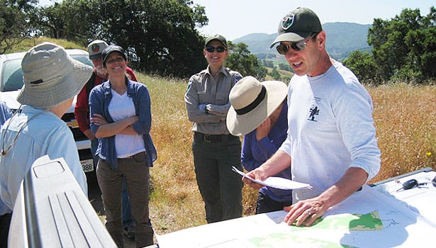 Parks staff and community leaders reviewing maps on site in open space